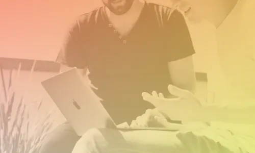 Two people chatting and looking at a laptop