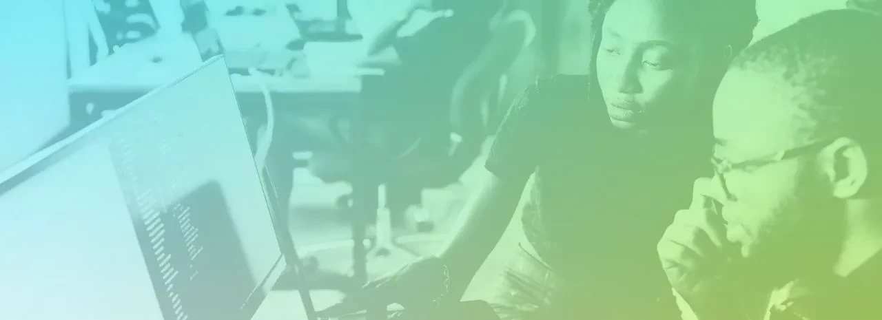 Two people looking a computer screen in an office