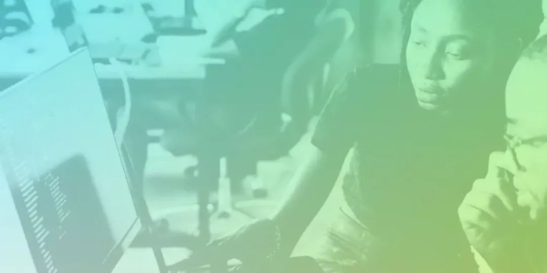 Two people looking a computer screen in an office